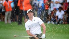 Rory McIlroy battles through  pain to remain in hunt
