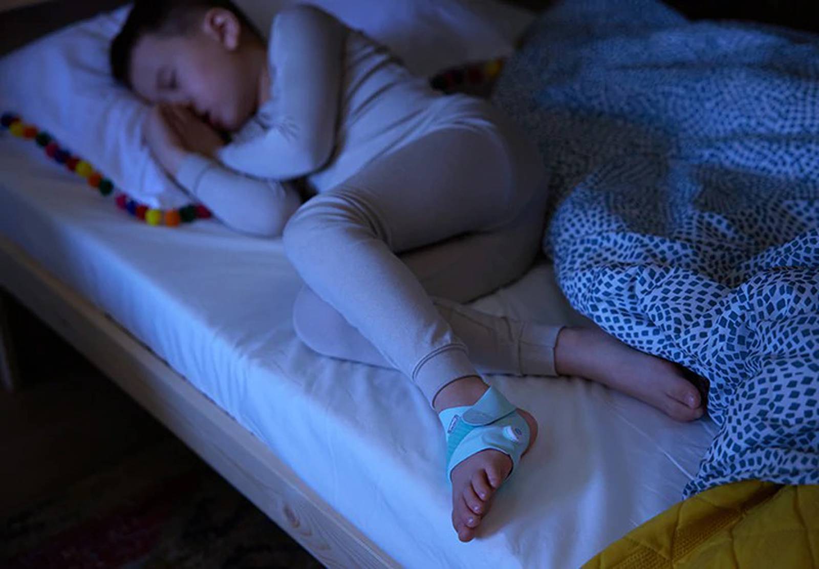 The Owlet Smart Sock Plus on a sleeping older child