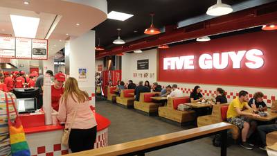 Losses at company behind State’s Five Guys franchise halved last year