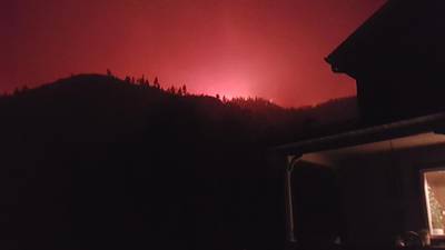 I watch the wildfire’s huge red glow as it approaches the hill above our house