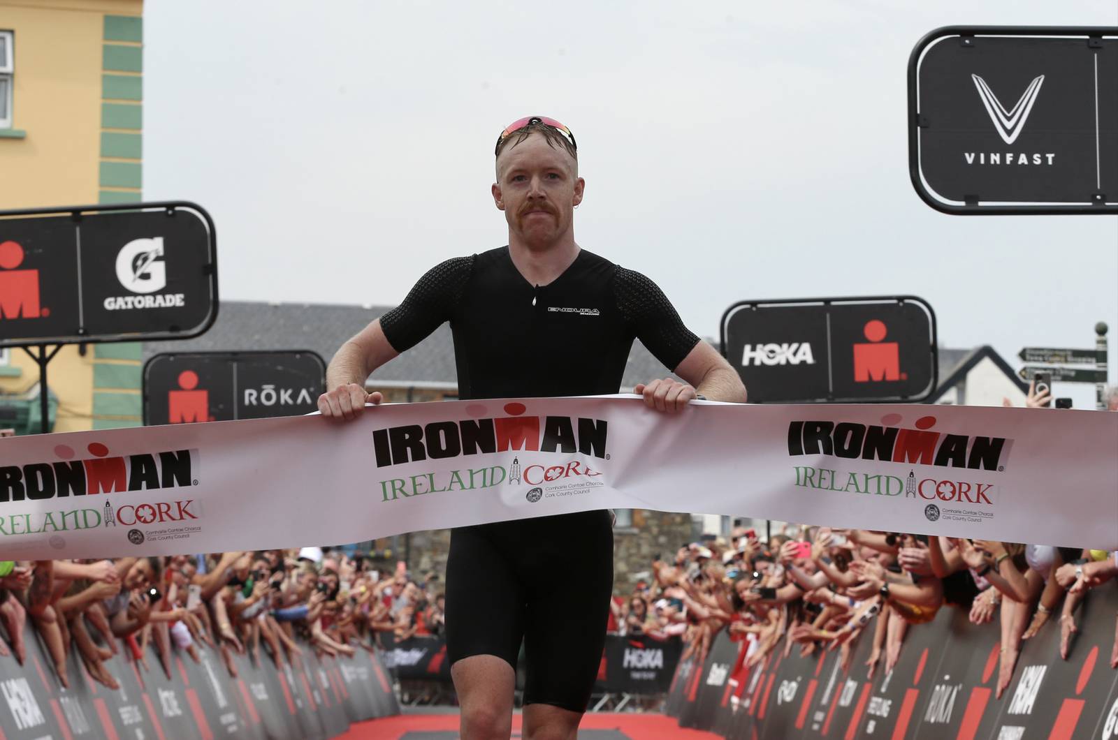 Chris Mintern from Cork crosses the finish line at the 2022 Youghal Ironman competition. Photograph: Siya Ndzimande/Ironman EMEA
