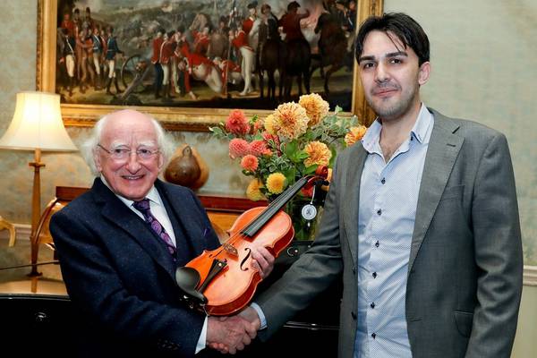 Syrian refugee presents violin he made to Michael D Higgins