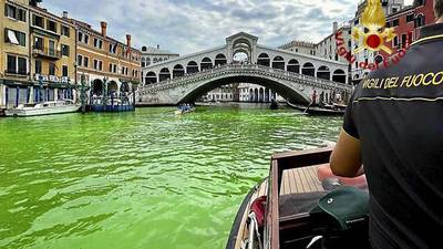 Venice canal turn fluorescent green near Rialto Bridge