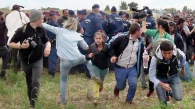 Hungarian camerawoman apologises for tripping migrants