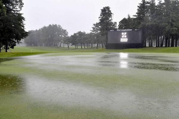 Tiger Woods must wait to build on lead in Japan due to heavy rain
