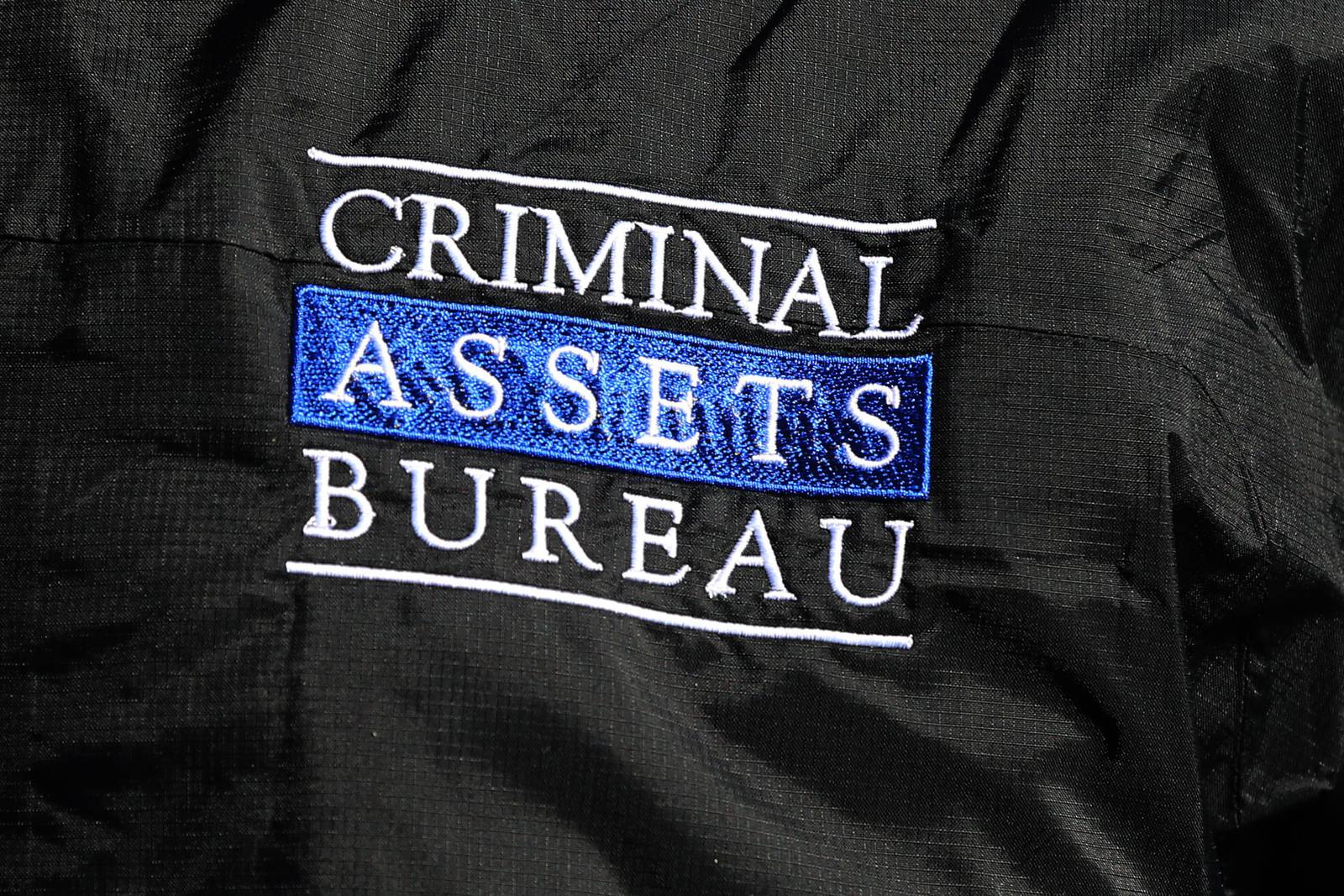 The logo on a jacket of a member of the Criminal Assets Bureau  carrying out searches on homes and businesses in Dublin targeting the activities of a south inner city-based crime group linked to David Byrne, who was murdered in the Regency Hotel.  PRESS ASSOCIATION Photo. Picture date: Wednesday March 9, 2016. See PA story POLICE Raids Ireland. Photo credit should read: Niall Carson /PA Wire