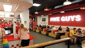 Losses at company behind State’s Five Guys franchise halved last year