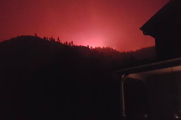 I watch the wildfire’s huge red glow as it approaches the hill above our house