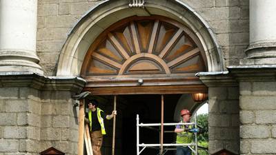 Work under way to restore  damaged Trinity College gate