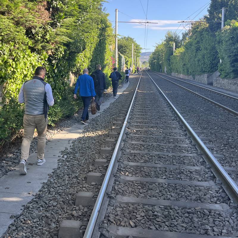 Commuters walk on Luas tracks after power outage with no indication when Green line service will resume