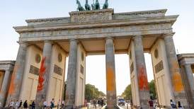 Climate activists spray-paint Berlin’s Brandenburg Gate with fiery colours
