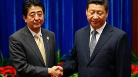 China’s Xi and Japan’s Abe shake hands in progress to ease regional tensions