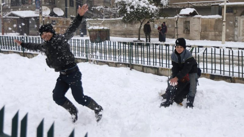 Children play in the snow in Douma, near Damascus on Sunday. Met Éireann has issued  status yellow warnings for snow and ice between Monday and Wednesday. Photograph: REUTERS/Bassam Khabieh
