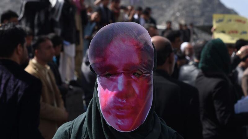 Afghan members of the Solidarity Party of Afghanistan wear masks bearing an impression of the bloodied face of a woman who was lynched by a mob during a protest against the attack in Kabul.  The body of Farkhunda, 27, who was lynched on was carried to the graveyard by women amid crowds of men, a rare act of protest in a male-dominated society. Photograph: Shah Marai/AFP