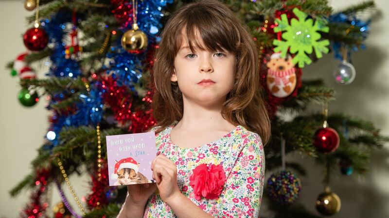 Florence Widdicombe (6) at her home in Tooting, south London, holding a Tesco Christmas card from the same pack as the one which contained a message from a Chinese factory worker. Photograph: Dominic Lipinski/PA Wire