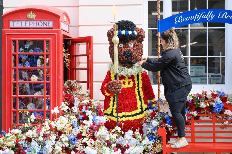 Florist Victoria Clemson from Neill Strain puts the finishing touches to a floral installation, 'Beefeater Teddy Bear', in Motcomb Street in London, which has been designed for the Belgravia in Bloom festival, running from May 23-29, London. Picture date: Monday May 23, 2022.