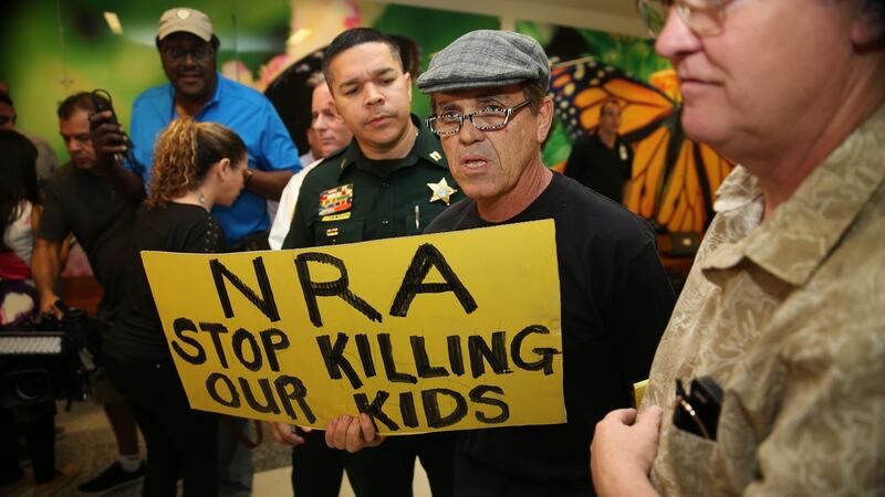 People protest against the National Rifle Association at the Broward County Court House during the first appearance in court via video link for high school shooter Nikolas Cruz. The heavily armed teenager who gunned down students and adults  was charged Thursday with 17 counts of premeditated murder. Photograph: Charles Trainor/ AFP