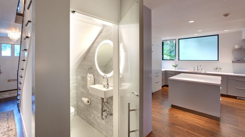 By utilising an otherwise empty space, such as this one under the stairs, you can install a small powder room in which guests can freshen up. Hugh Jefferson Randolph Architects