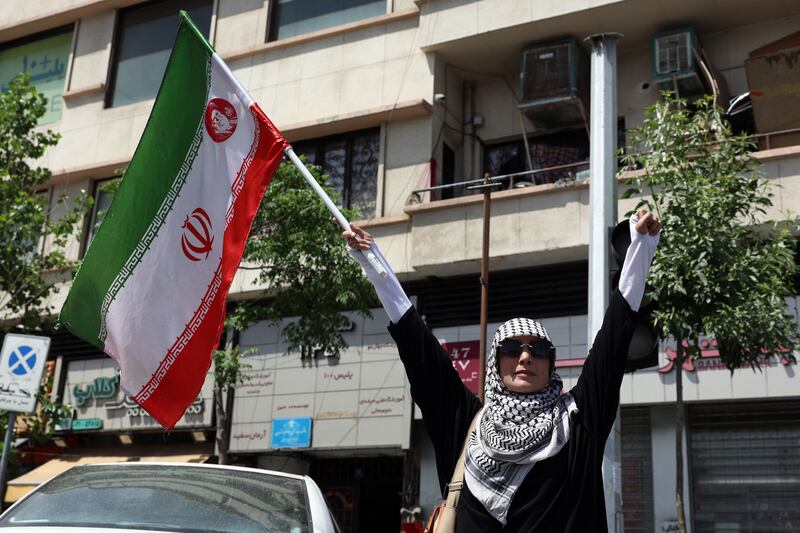 A woman holds Iran's national flag at Enghelab (Revolution) Square in Tehran on Thursday. Photograph by Abedin Taherkenareh/EPA