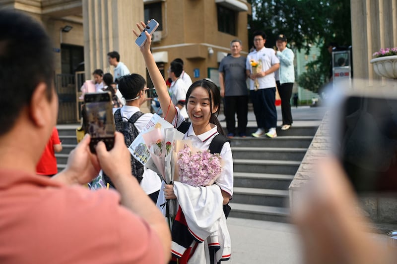 A student reacts as she is presented with flowers at the end of the national college entrance examinations, known as the gaokao, in Beijing. Photo: Wang Zhao / AFP