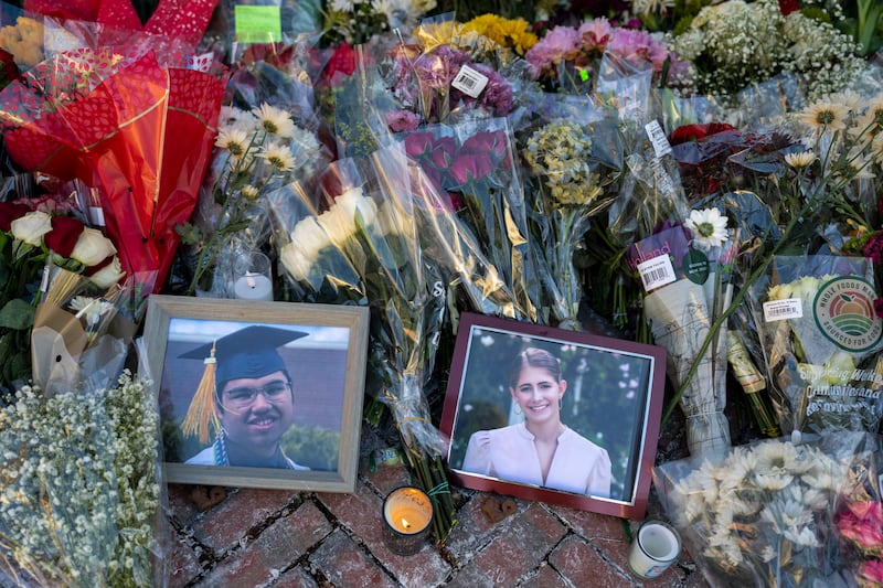Flowers and framed photographs of victims Makhammad Aziz Umurzokov and Ella Cook left at a makeshift memorial at the Van Wickle Gates of Brown University on Tuesday. Photograph: Christopher Capozziello/The New York Times