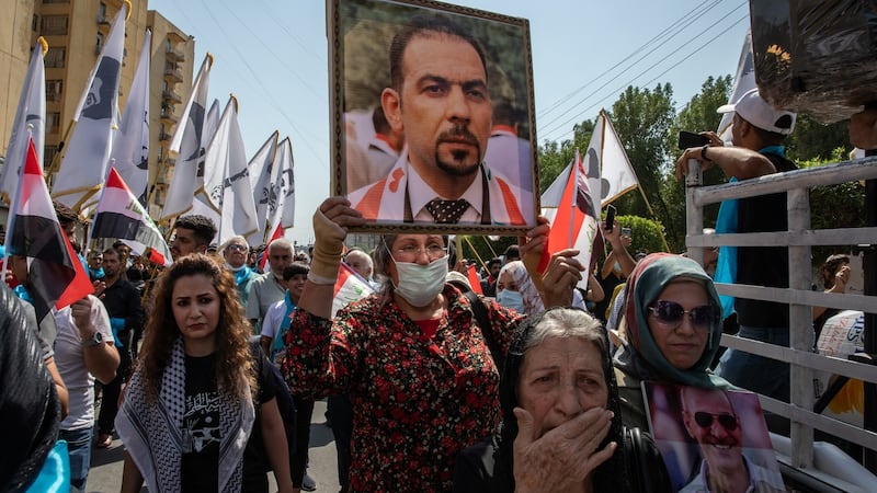 An anti-government protester carries a photograph of the slain activist Ehab Al-Wazni at a demonstration in Baghdad on October 1st. Photograph: Andrea DiCenzo/New York Times