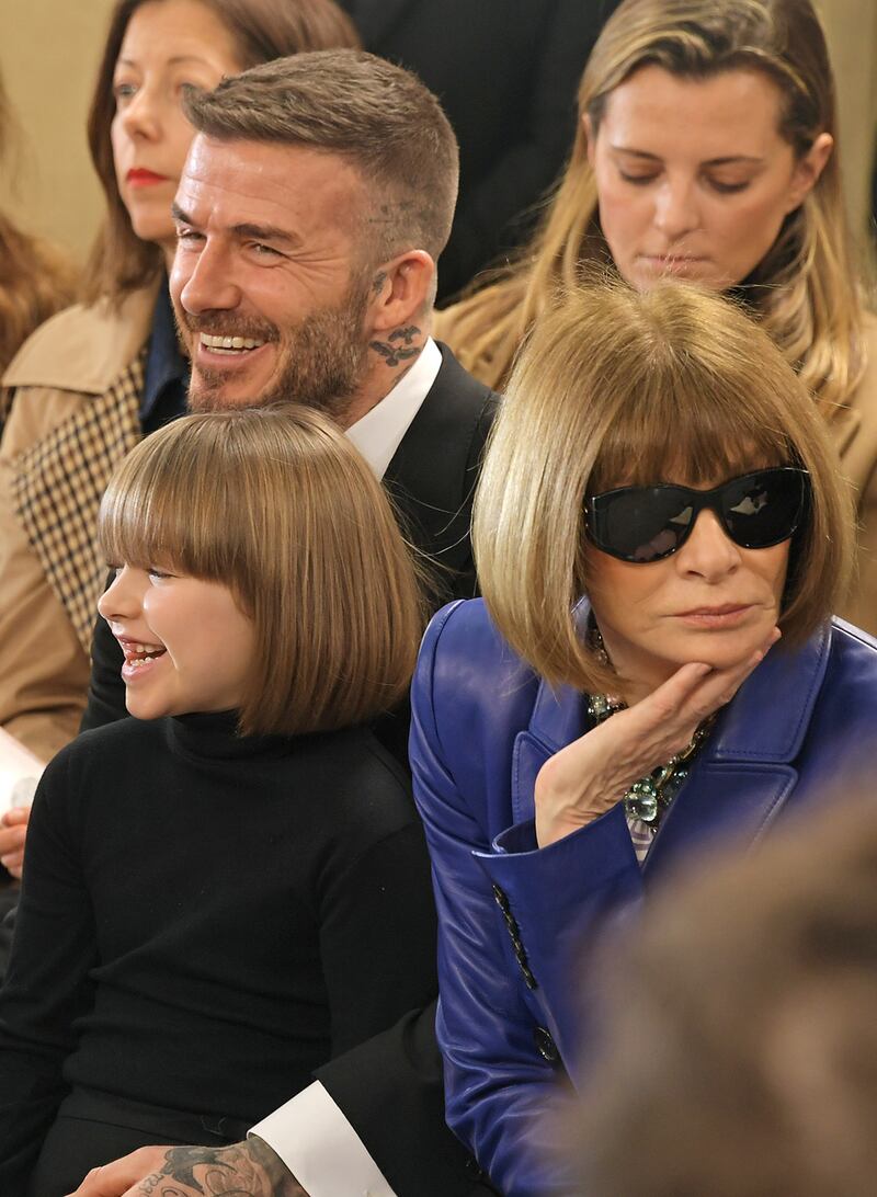 Harper Beckham, David Beckham and  Anna Wintour at the Victoria Beckham show during London Fashion Week, February 2019 at Tate Britain. Photograph:  David M. Benett/Getty Images