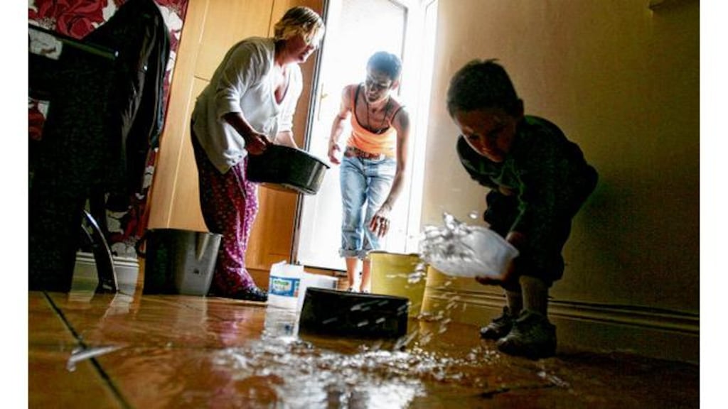 Rita Gavin helping her sister Marian Gavin and her nephew Jack Gavin clear water from their basement apartment on Ballybough Road, Dublin, after flooding in July 2009 photograph:: alan betson