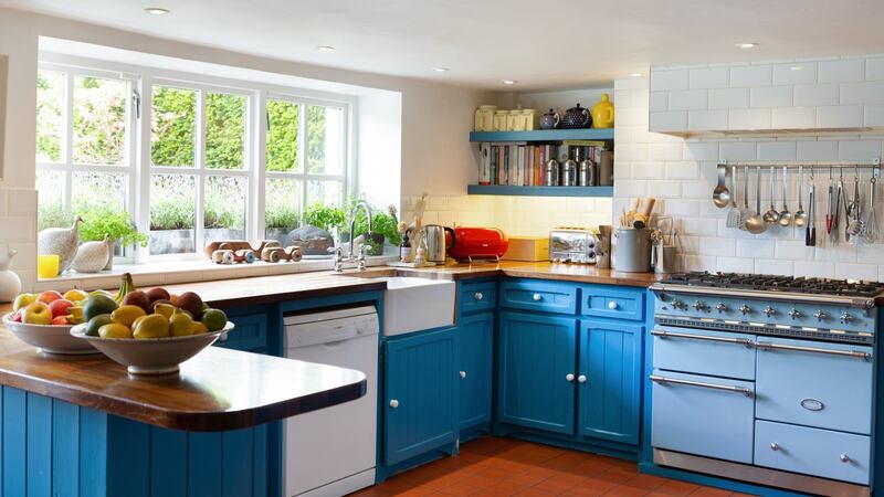 Pretty country kitchen and breakfastroom in the basement with  timber countertops, a pale blue Lacanche range, blue dresser and units painted bright blue (Air Force blue from Little Greene Paints).