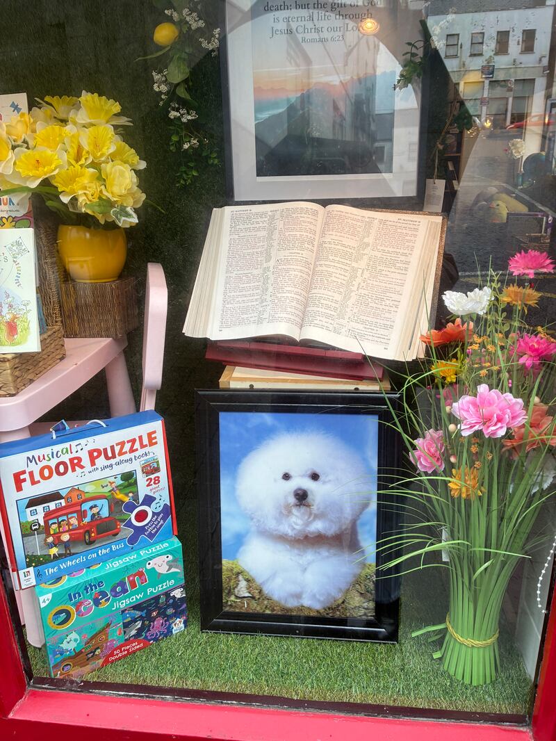 The Burke family's  shop window display of children’s books and games and a Bible, opened on a page about The Parable of the Two Sons