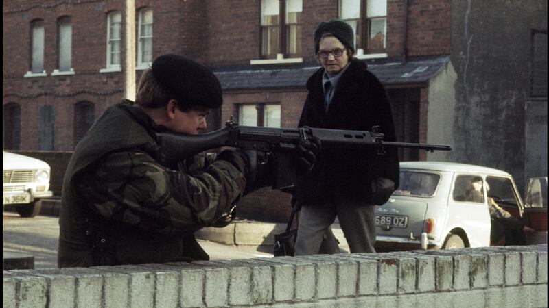 A woman eyes a British soldier on patrol in the republican New Lodge district of Belfast in January 1972. Photograph: Alex Bowie/Getty Images