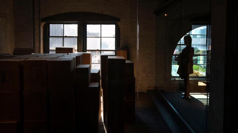 A woman looks toward an enclosed area on the sixth floor of The Sixth Floor Museum at Dealey Plaza, also known as the former Texas School Book Depository. Photograph: Adrees Latif/Reuters
