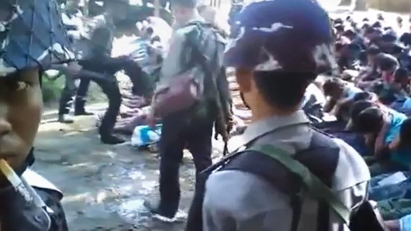 Screen grab taken on January 4th, 2017 from a YouTube video originally taken by Myanmar Constable Zaw Myo Htike (pictured at far left - looking at camera) shows a policeman kicking out at a Rohingya minority villager seated on the ground with others, in the village of Kotankauk during a police area clearance operation. Photograph: Zaw Myo Htike/AFP/Getty Images