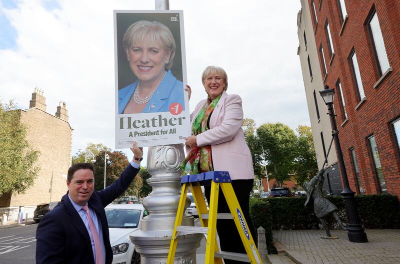 Heather Humphreys putting a poster on a pole on Mount Street, Dublin, assisted by Martin Heydon. Photograph: Alan Betson