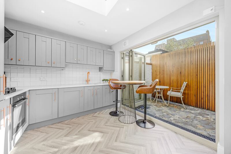 Bifold doors at the rear of the kitchen open on to a small tiled courtyard