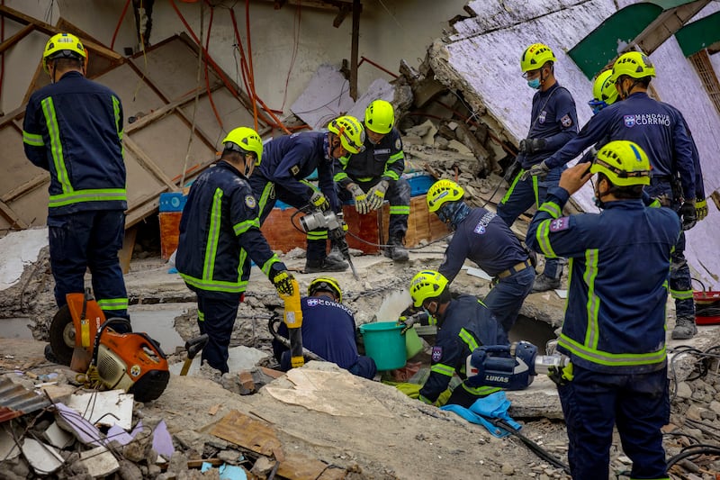 Rescue workers search for survivors under the rubble of a collapsed residential building in Bogo, Cebu province. Photograph: Ezra Acayan/Getty Images