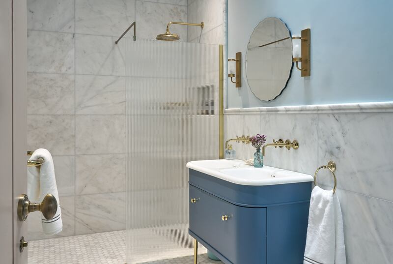 A bathroom design by Elaine Verdon incorporates soothing blues and chic brass touches