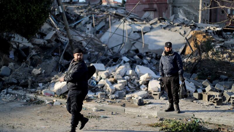 Palestinian policemen  stand guard on Tuesday at the site of a Hamas-run insurance office after it was destroyed by an Israeli air strike in Gaza City. Photograph: Mohammed Salem/Reuters.