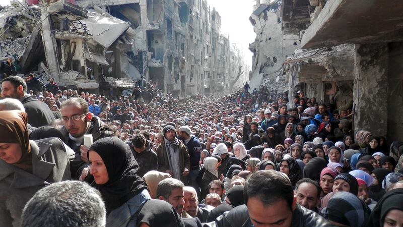 A file photograph of people waiting in line for food at the Yarmouk refugee camp in Damascus, taken on January 31st, 2014. Photograph: United Nation Relief and Works Agency via Getty Images