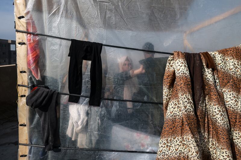 A woman hanging laundry in a camp set up by Palestinians who fled Khan Yunis and moved south to Rafah. Photograph: Mohammed Abed/AFP via Getty Images