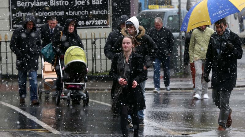 Members of the public get caught in a brief snow shower in Dublin. Photograph: Laura Hutton/Collins Photo Agency