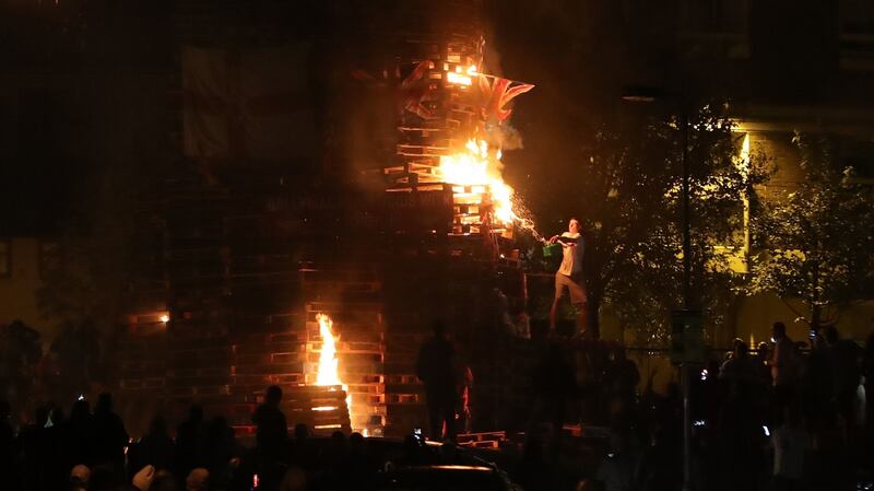 A man lights the bonfire  to mark the anniversary of the introduction of the controversial policy of internment without trial. Photograph: PA Wire
