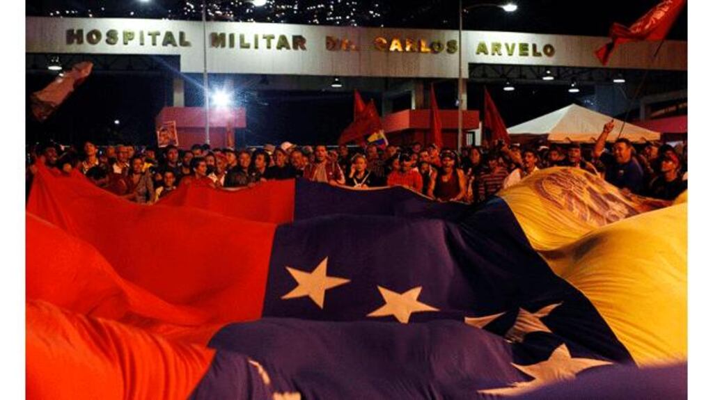 Supporters of Venezuela's President Hugo Chavez react to the announcement of his death outside the hospital where he was being treated in Caracas yesterday. Photograph: Reuters