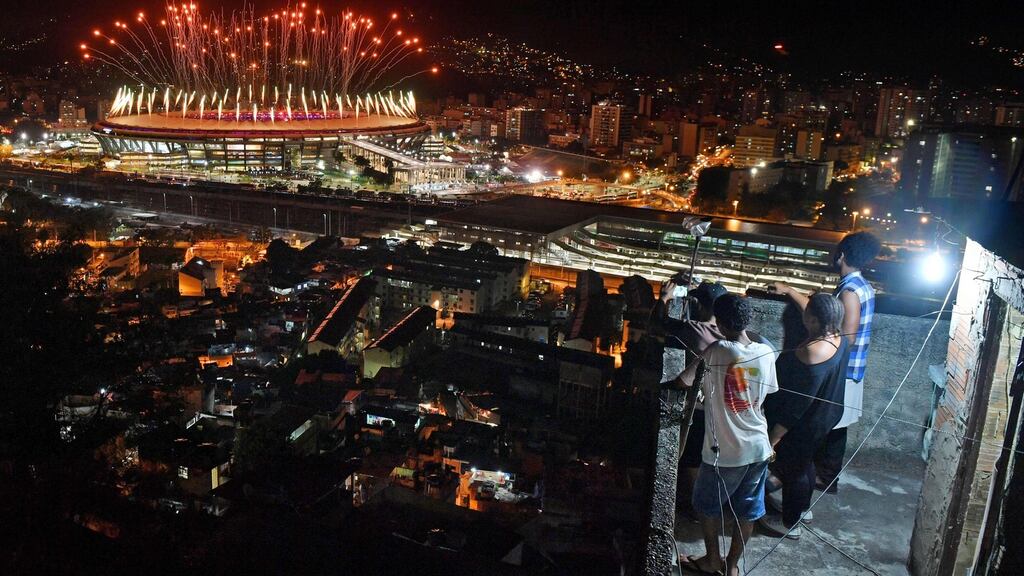 People watch fireworks exploding over the Maracana stadium, from a terrace in the favela Mangueira, during the opening ceremony of the Rio 2016 Olympic Games in Rio de Janeiro. Photograph: Andrej Isakovic/AFP/Getty Images