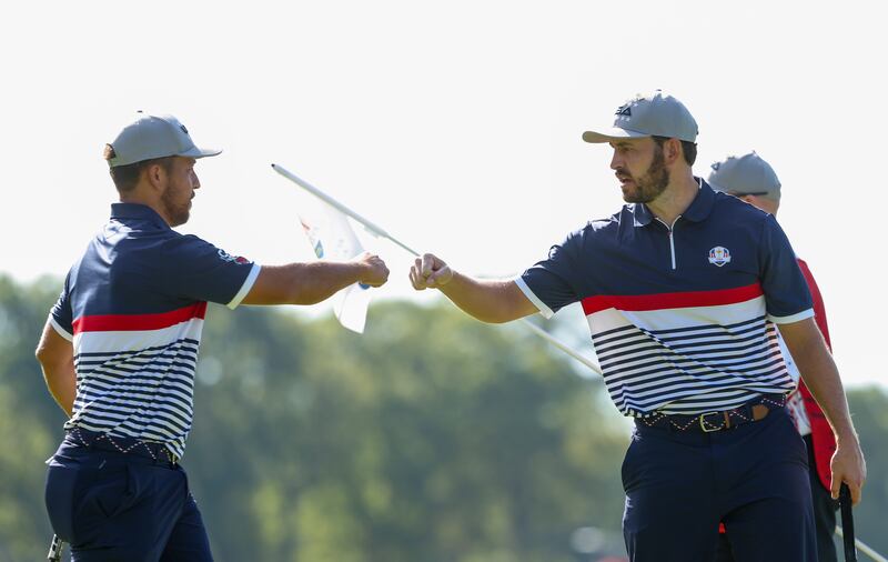 Xander Schauffele fist bumps teammate Patrick Cantlay of Team United States. Photograph: Jamie Squire/Getty