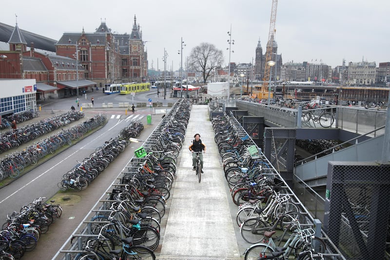 A man rides a bicycle near Amsterdam's main train station. Photograph: Paulo Amorim/VW PICS/Universal Images Group Getty Images