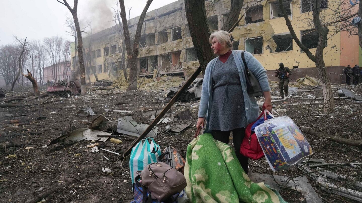 A woman walks outside the damaged by shelling maternity hospital in Mariupol. Photograph: Evgeniy Maloletka/AP