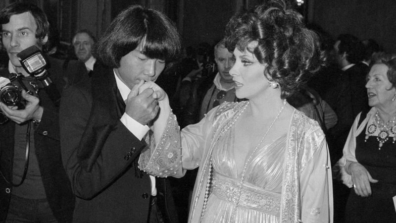 Kenzo Takada kisses the hand of Gina Lollobrigida after she noted him as one of the 10 most elegant men in the world, in Rome, Italy in December 1977. Photograph: AP