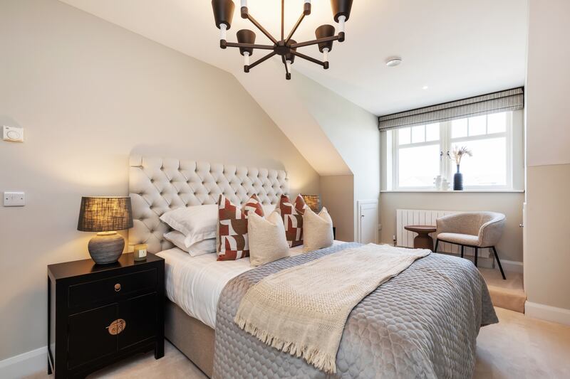 On the second floor, the bedroom has a raised seating area under the front window, with lots of eaves storage on both sides.