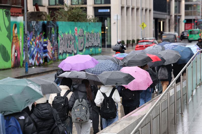 Tourists shelter under umbrellas from the heavy rain in Dublin on Monday. Photograph: Dara Mac Dónaill